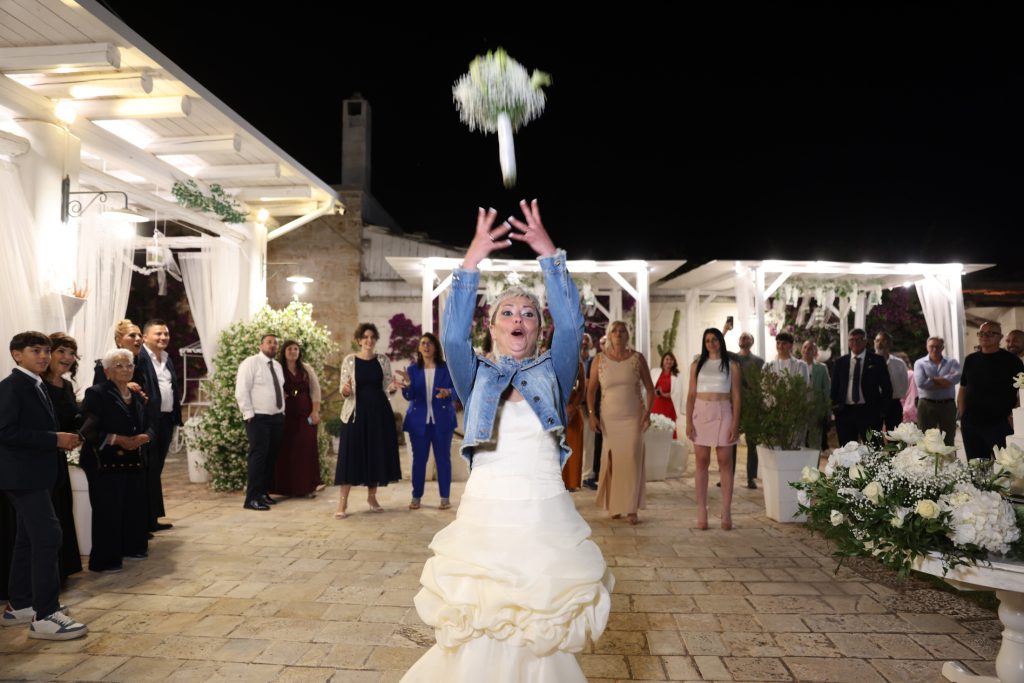 La sposa lancia il bouquet durante la festa