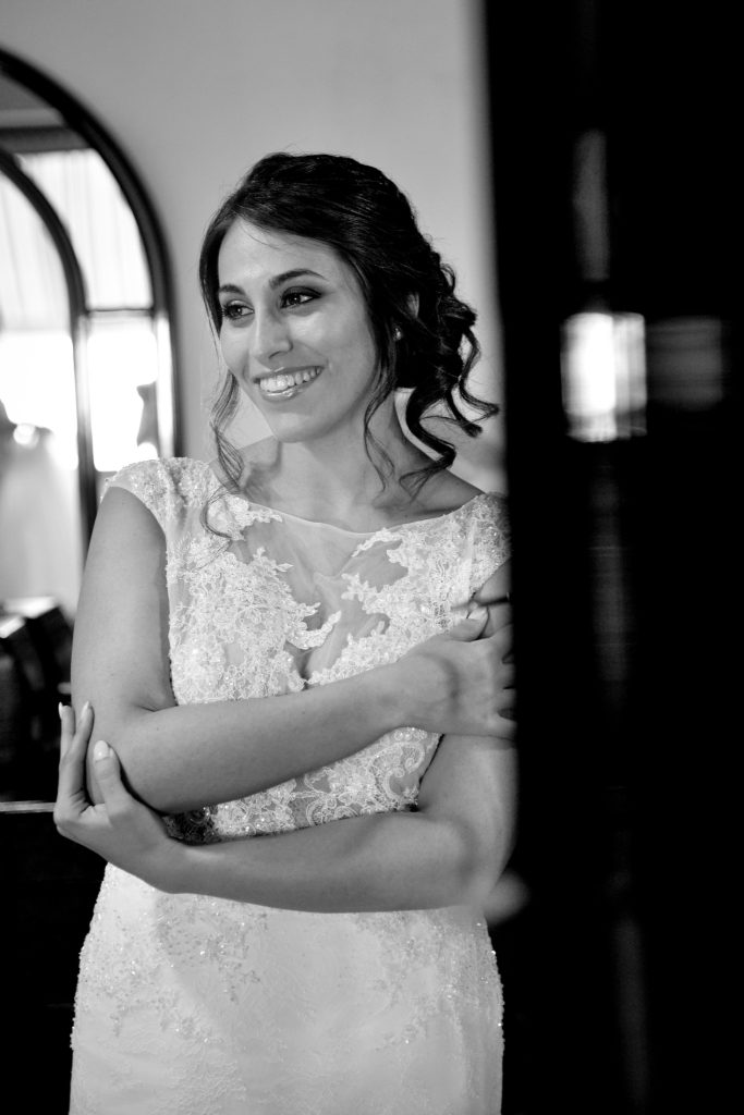 La sposa sorride durante i preparativi, in bianco e nero