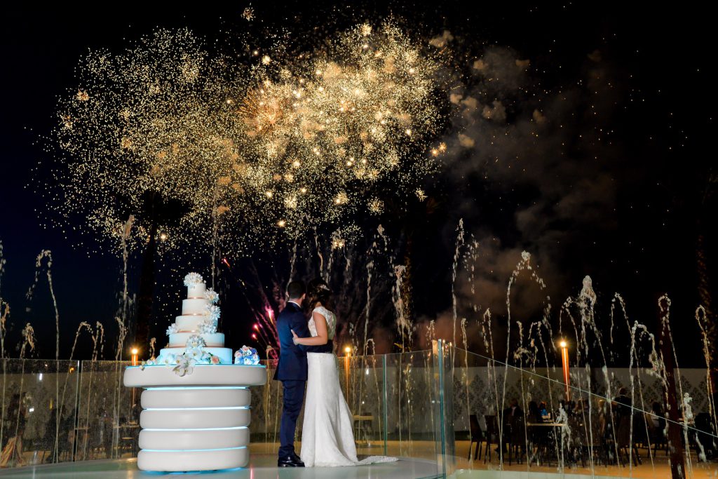 Gli sposi al taglio della torta sotto i fuochi d’artificio