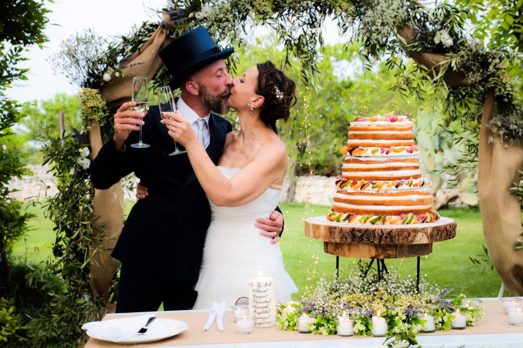 Gli sposi festeggiano accanto alla torta