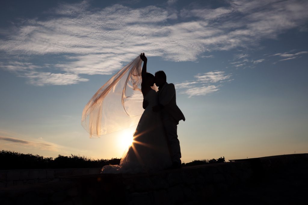 Gli sposi e il velo al tramonto