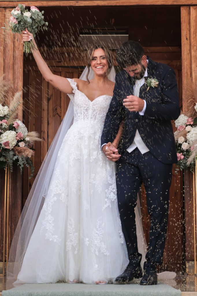 La sposa alza il bouquet all’uscita – matrimonio di Cosimo e Dominga