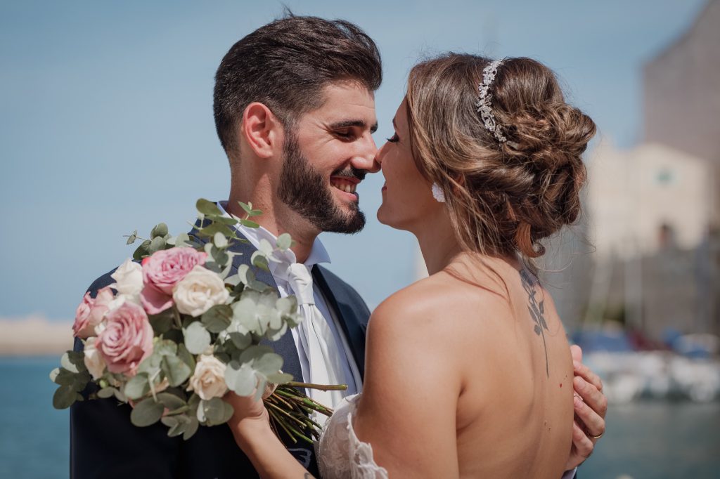 Gli sposi si sorridono vicino al bouquet – matrimonio di Cosimo e Dominga